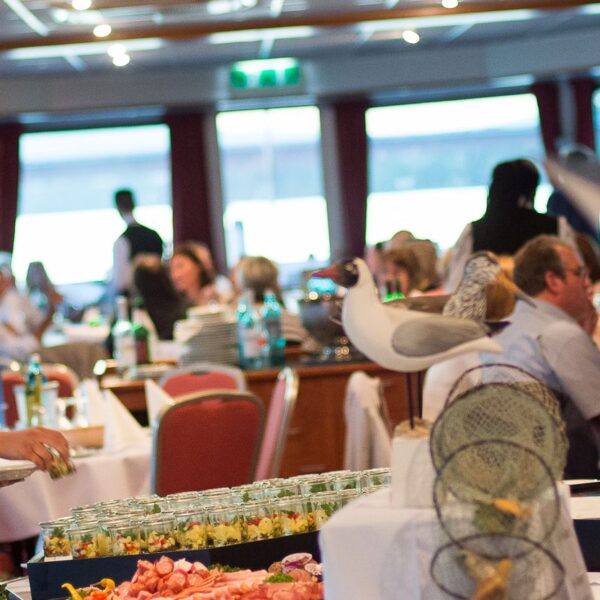 Adventsbrunch Mainz, wo eine Frau kleine Gläschen mit Salate abstellt.