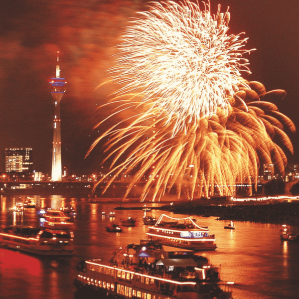 Schiffe auf dem Rhein in Düsseldorf im Dunklen vor Feuerwerk