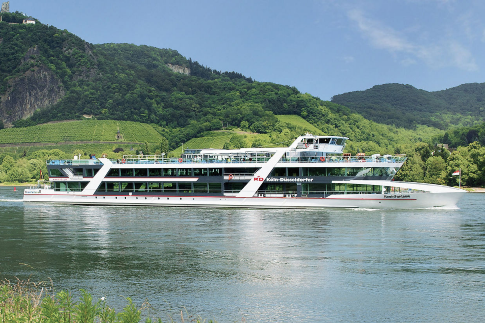 Linienfahrten auf dem Rhein. MS RheinFantasie auf dem Rhein vor Felsen und Weinbergen