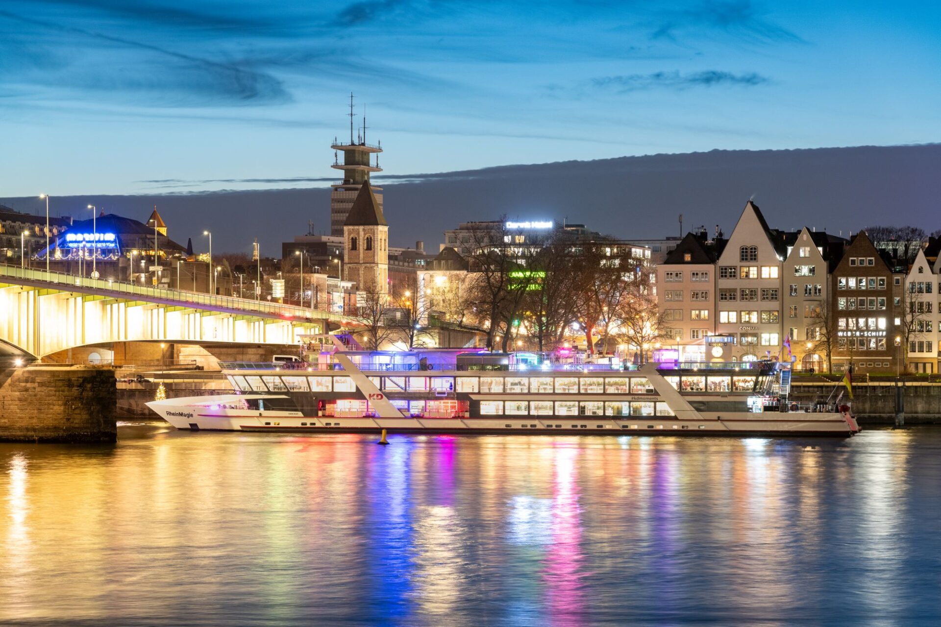 MS RheinMagie abends beleuchtet vor der Deutzer Brücke