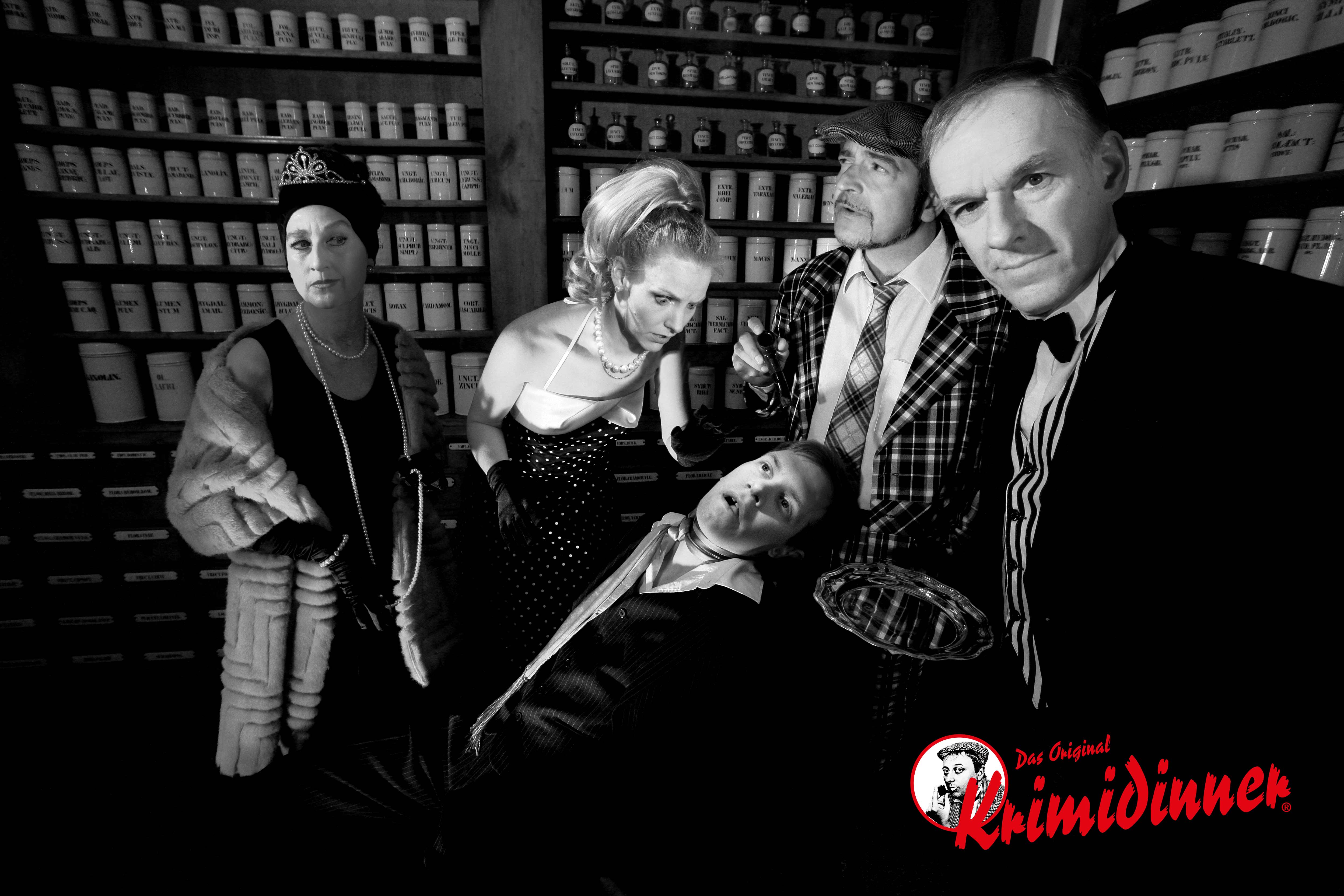 Four people looking at a dead man