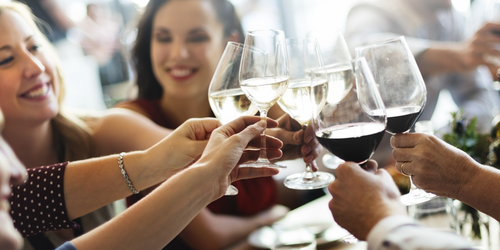 Frauen stoßen mit Wein an