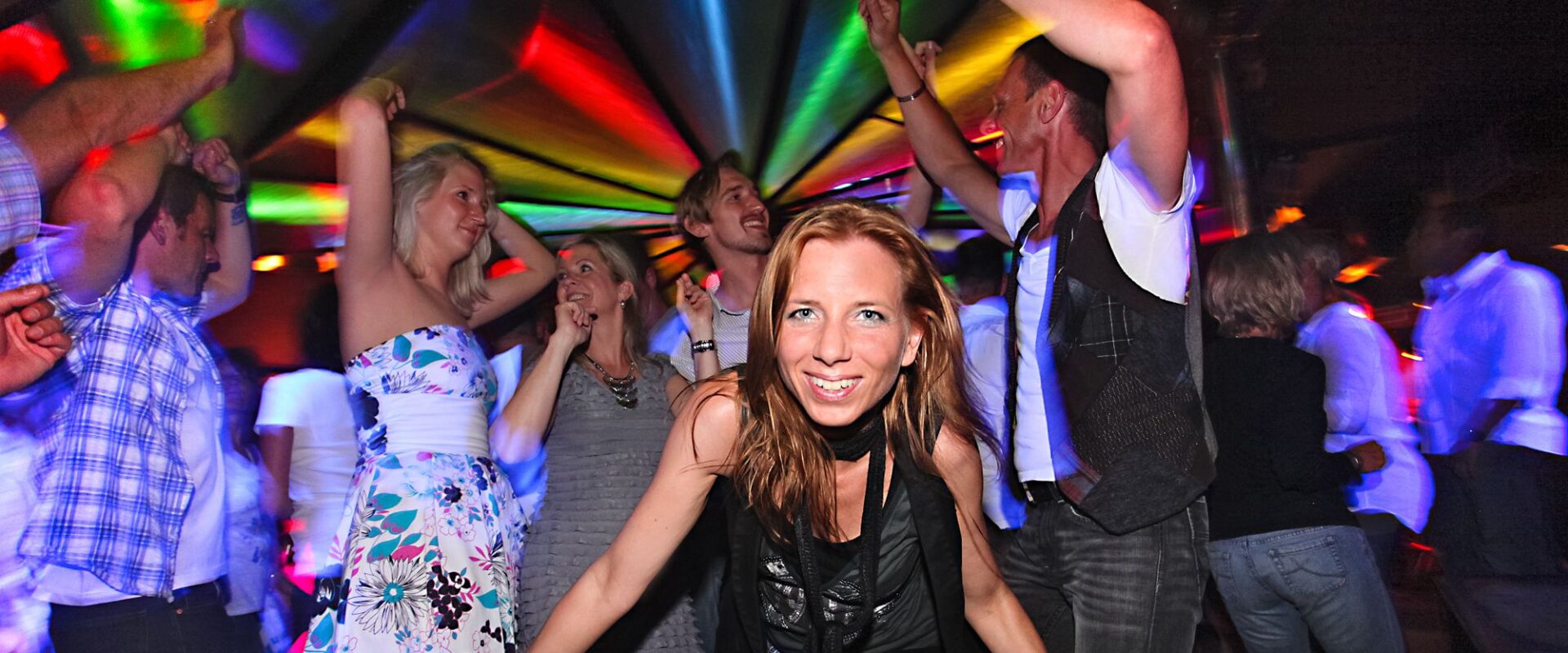Frau auf einer Party lacht in die Kamera