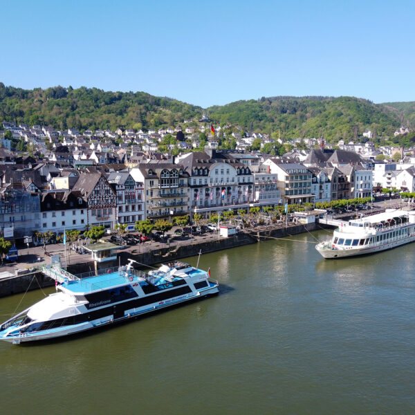 View of the ships MS RheinKrone and MS Asbach on the Middle Rhine. Both ships are moored at landing stages.