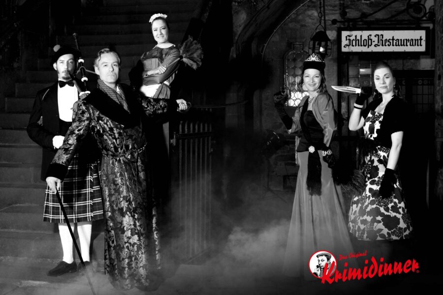 Two men and three women stand in the castle restaurant in disguise and hold weapons in their hands - fitting for a murder mystery dinner