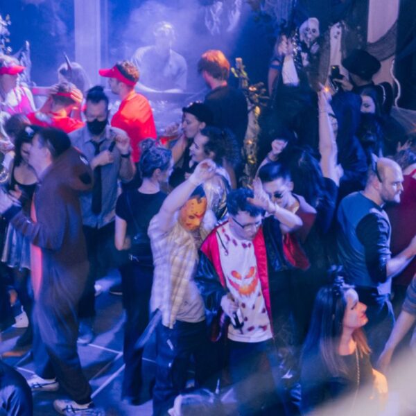 Disguised people celebrating in the interior of a ship, photographed through spider webs as decoration on board