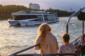 Evening cruise Cologne: Two women look down from the railing onto the MS RheinMagie at dusk