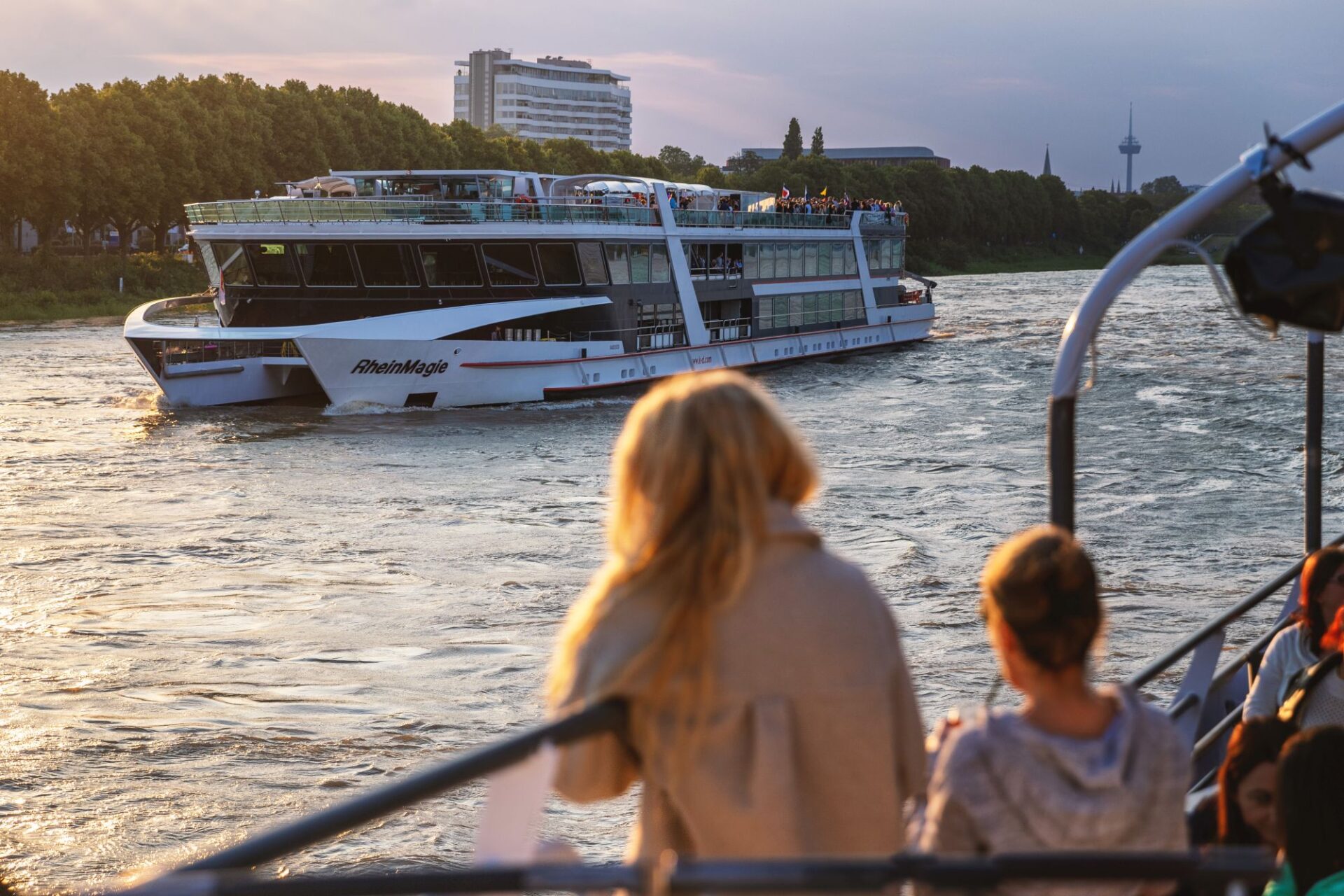 Abendfahrt Köln: Zwei Frauen schauen von der Reling auf die MS RheinMagie in der Abenddämmerung